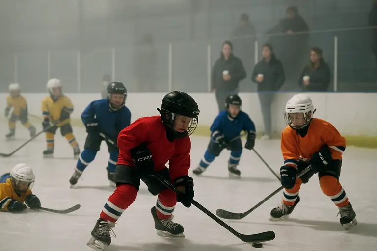 A hockey coach watches under-18 players during a bench discussion